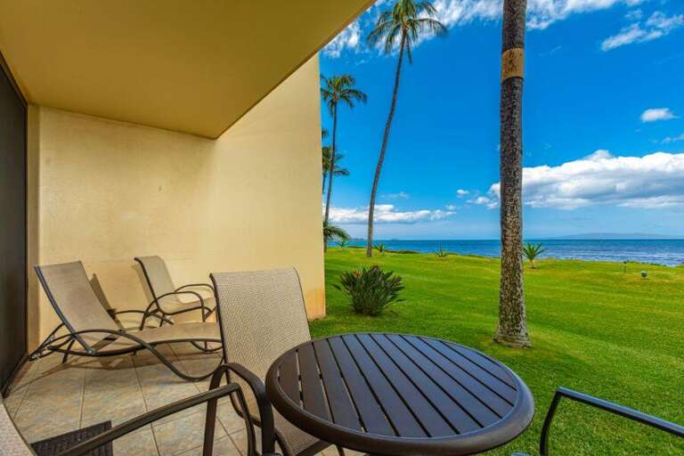 Balcony View With Chairs Overlooking Sea Scene, Lush Lawn Lined By Palm Trees
