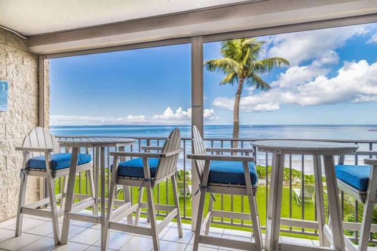 Balcony View Of Blue Sea, Palms, And Clear Skies
