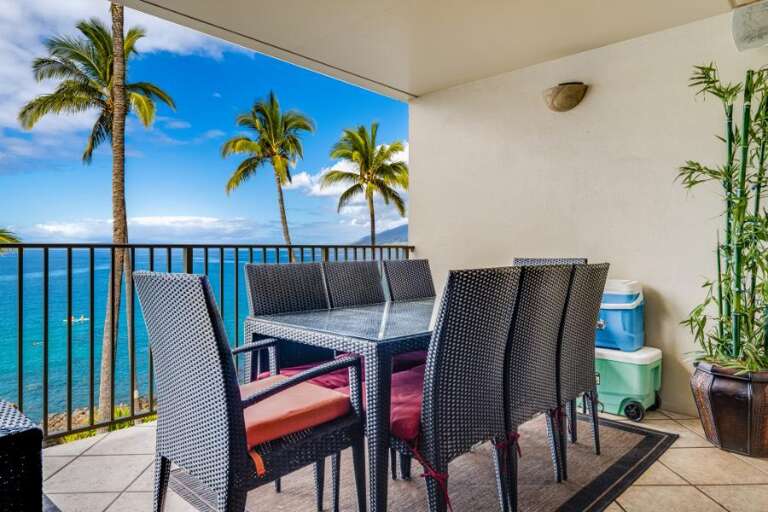 Patio Seating By The Sea With Swaying Palms And A Serene Sky