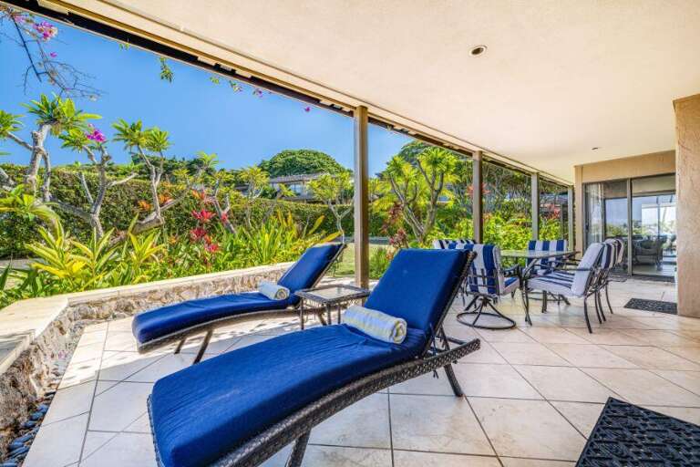 Patio With Blue Loungers Overlooking Lush Garden