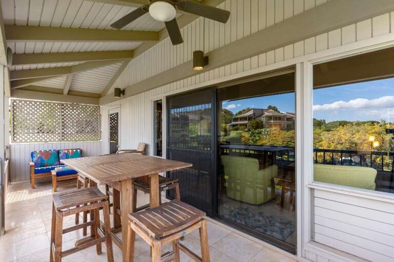 Balcony View With Wooden Furniture, Ceiling Fan, Sliding Glass Doors, And Distant Hills