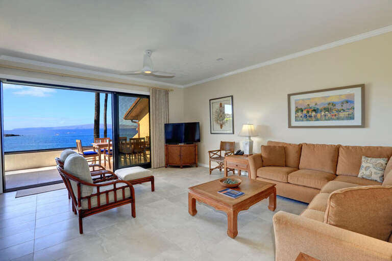 Seaside Vacation Rental Living Room With Ocean View, Plush Seating, And Sliding Glass Door Leading To Balcony