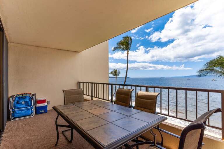 Balcony View Of Beach With Palms And Patio Set