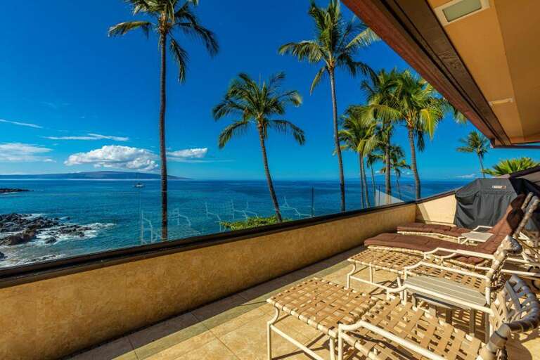 Balcony View Of Blue Ocean, Palm Trees, And Clear Sky