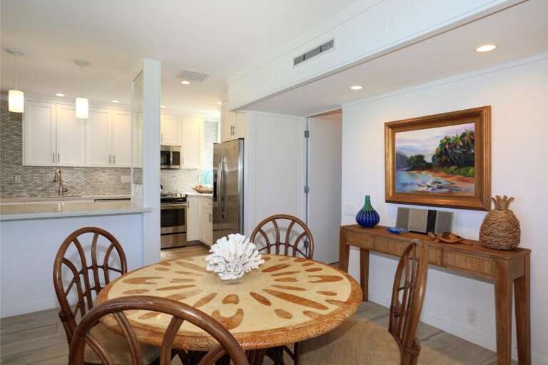 Light-filled Living Space With Kitchen, Coastal Decor Dining Table, And Ocean Painting