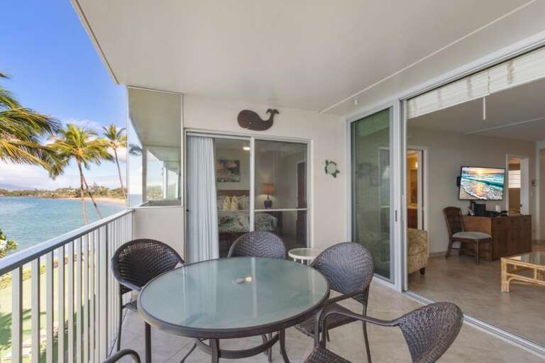 Balcony By The Bay With Table, Chairs, Sliding Doors, And Seaside View