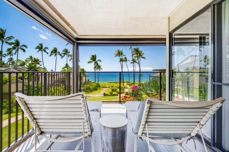 Balcony View With Bright Beach, Blue Sea, And Breezy Palms