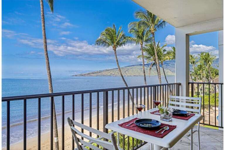 Balcony View With Beach, Breezes, Palm Leaves Shadowing Table Set For Two