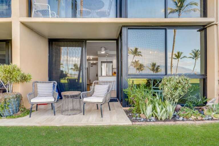 Seaside Vacation Rental With Sliding Doors, Striped Chairs, And Lush Plants