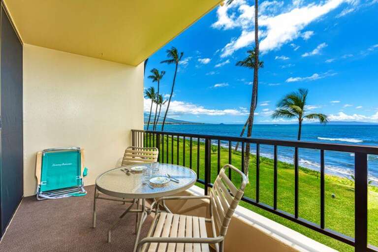 Balcony Boasting Beach View With Chairs And Table Facing Palm Trees And Sea
