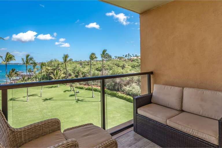 Balcony View Of Blue Bay Bordered By Green Grass