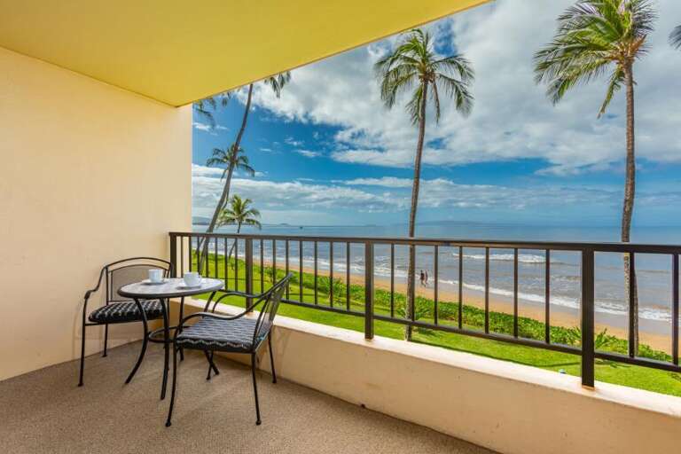 Balcony View Of Beach With Breezy Palms And A Serene Sea
