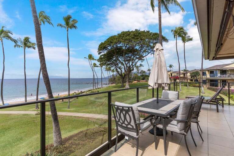 Balcony View Of Breezy Beach With Palms And Patio Furniture