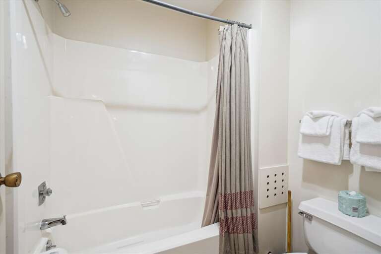 Full sized bathroom with a bathtub/shower combination.