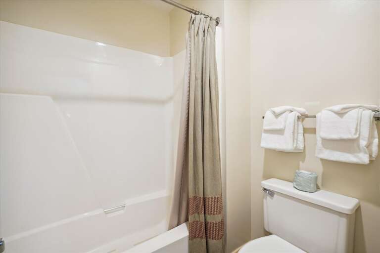 Full sized bathroom with a bathtub/shower combination.