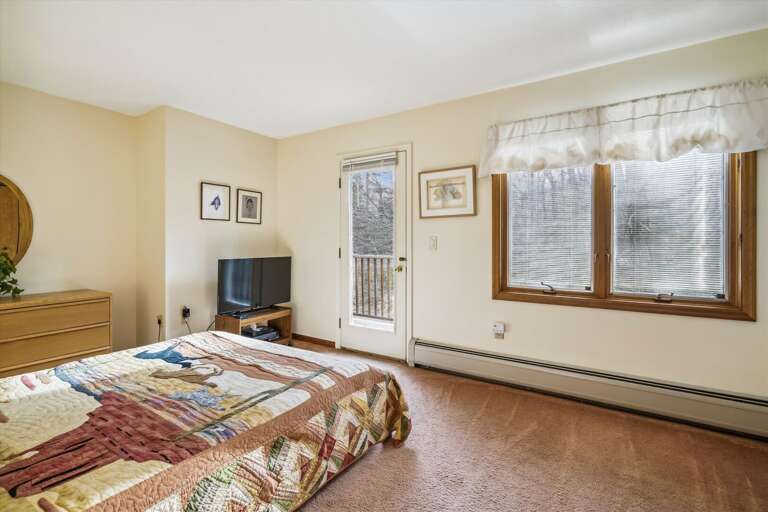 A well lit bedroom. Go out on the small balcony.