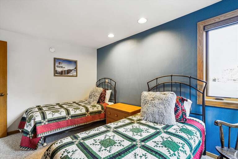Twin Beds With Patterned Bedspreads In A Room With Blue Accent Wall Twin Beds With Patterned Bedspreads In A Room With Blue Accent Wall