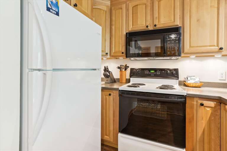 This kitchen has a stove, dishwasher, microwave, toaster, and a coffee maker.