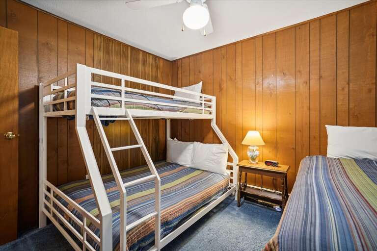 This bedroom has bunk beds and an additional twin bed.