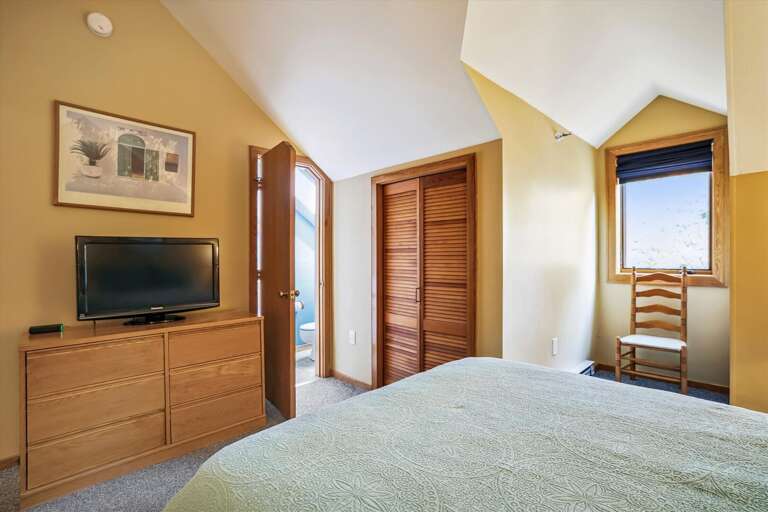 Modestly decorated w/ warm lighting queen bedroom.