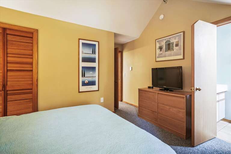 Modestly decorated w/ warm lighting queen bedroom.