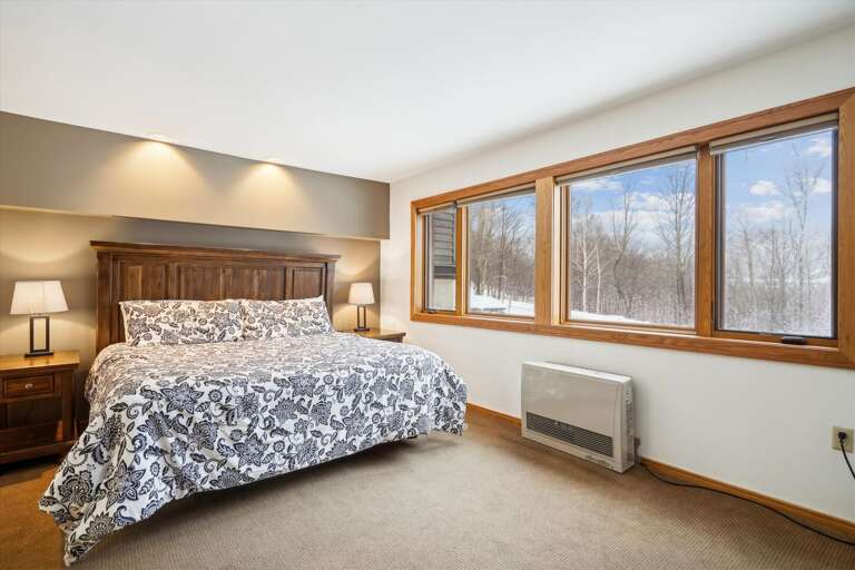 Bedroom With Broad Bed, Big Windows, Bare Branches Beyond