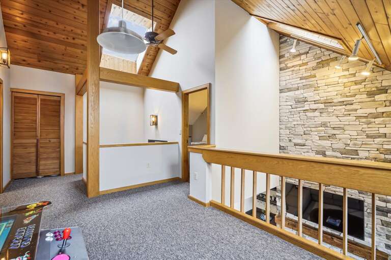 loft area with futon for seating and old timey arcade game!