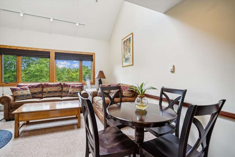 Living Room With Dining Table, Sofa, And Large Windows