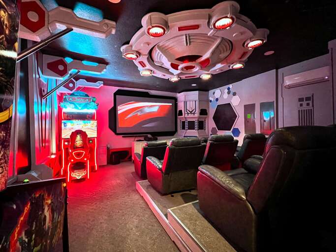 Futuristic Theater Room With Plush Seats, Vibrant Screens, And Neon Lights