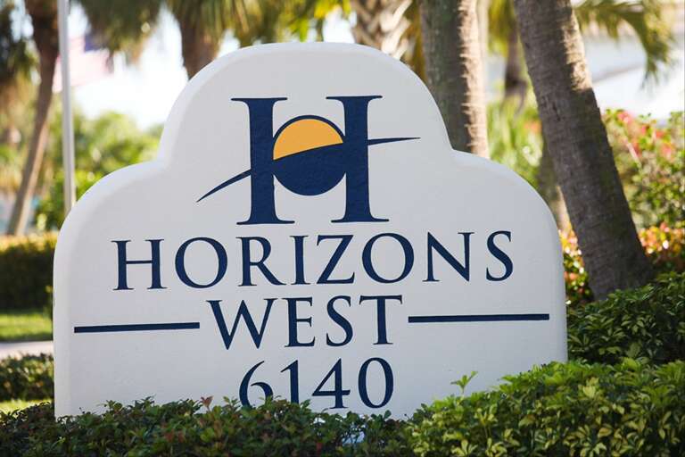 Sign For Horizons West With Palm Trees In Background