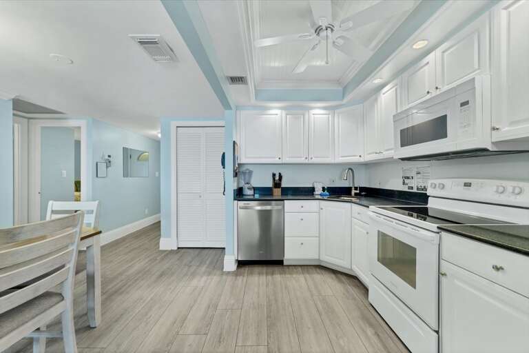 Bright Kitchen Interior With White Cabinets And Stainless Steel Appliances