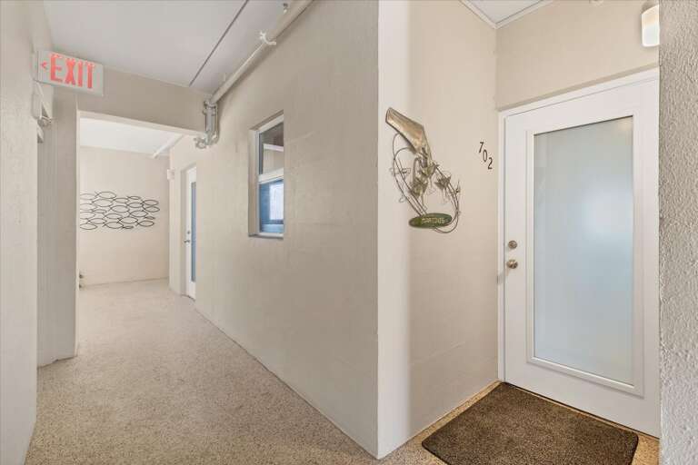 Indoor Hallway With Numbered Doors And Decorative Wall Hangings