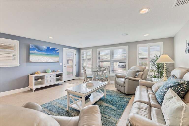 Light-filled Living Space With Plush Seating And Beach-themed Decor