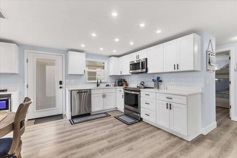 Spotless Spacious Kitchen In Vacation Rental, With White Cabinetry And Sleek Appliances
