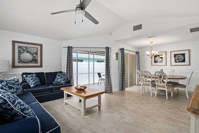 Spacious Living Space With Sleek Sofa, Serene Sea View Through Sliding Doors, And Simple Dining Set Spacious Living Space With Sleek Sofa, Serene Sea View Through Sliding Doors, And Simple Dining Set