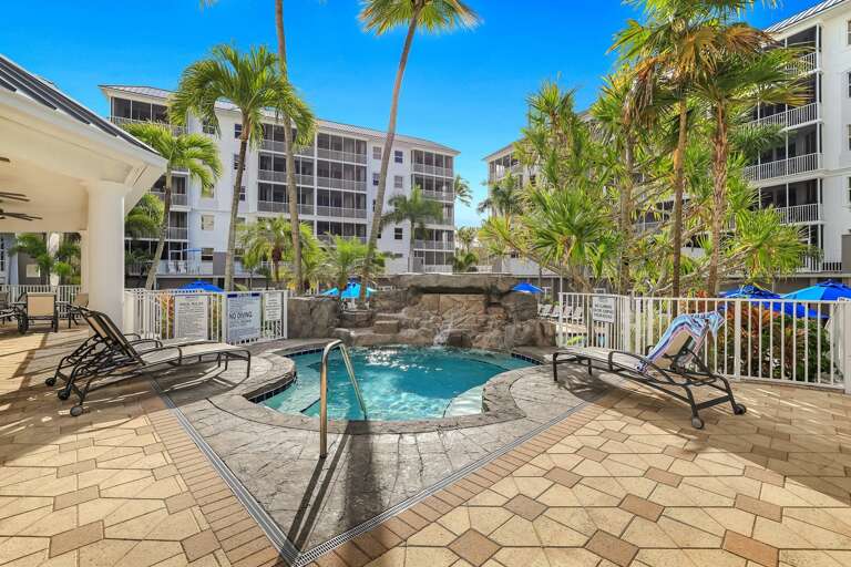 Palm-lined Poolside With Lounge Chairs And Bubbling Jacuzzi