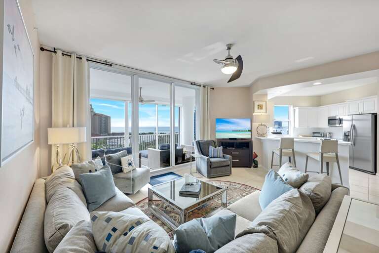 Spacious Living Area With Sea View, Plush Sofas, And Kitchen Counter
