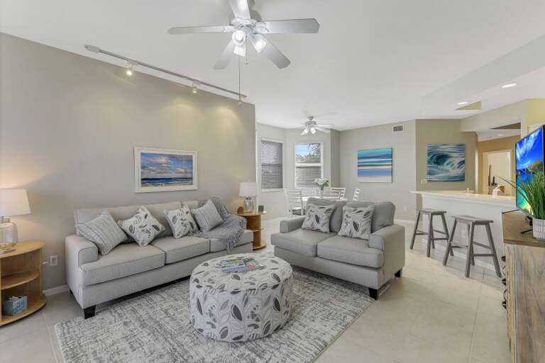 Living Room Interior With Sofas, Ottoman, And Kitchen Bar Stools
