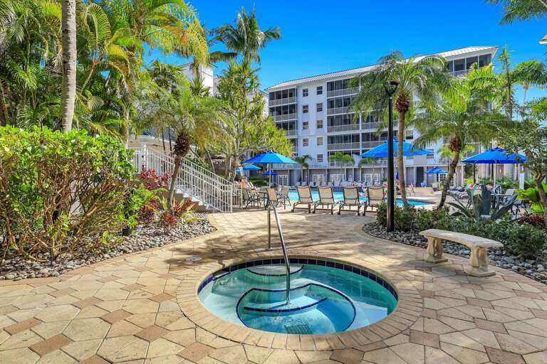 Palm-lined Path, Bubbling Hot Tub, Lounge Chairs, Blue Umbrellas