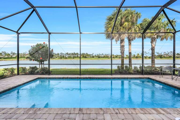 Screen-enclosed Outdoor Pool With Palm Trees And Lake View