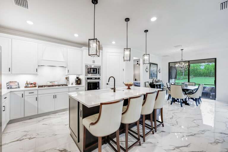 White Kitchen Interior With Island And Pendant Lights White Kitchen Interior With Island And Pendant Lights