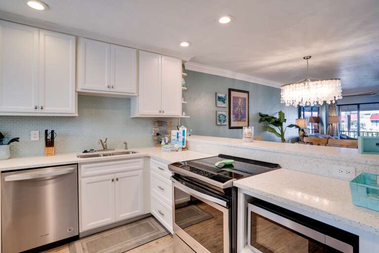 Spacious Kitchen With Sleek Surfaces, Stainless Steel Appliances, And Light-hued Cabinets