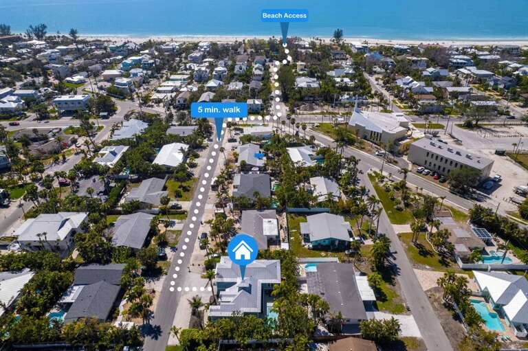 Aerial View Showcasing A Street Leading To The Sea, Surrounded By Small Buildings And Palms