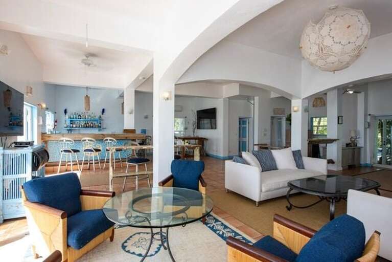 Spacious lounge area with sofas, a very large dining room, commercial kitchen, full bar and bar area with flat screen TV, and men's and women's rest rooms.