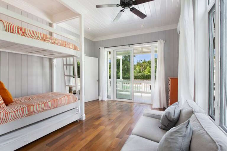 Poolside bunk room with twin bunk bed and trundle bed, and en-suite bath.