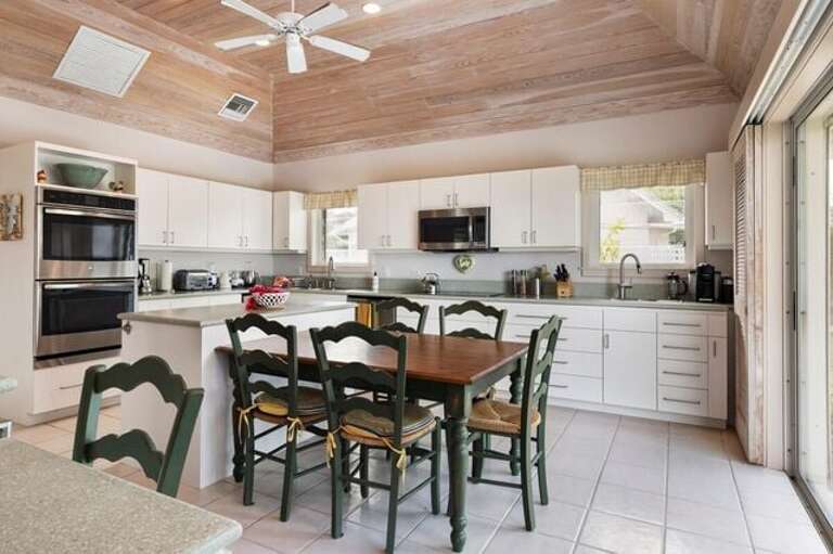 Fully equipped gourmet kitchen with quartz island and breakfast table.