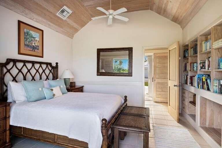Main House second bedroom with queen bed, ocean view, and powder room with outdoor shower