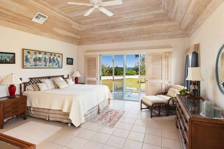 Master bedroom with king bed, en-suite bath, walk-in closet, and ocean view.