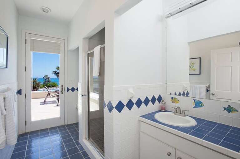 Bathroom with walk-in shower and door to patio and beach Bathroom with walk-in shower and door to patio and beach