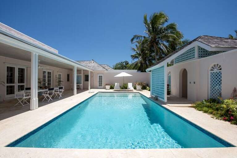 Pool and deck with lounge chairs and seating.